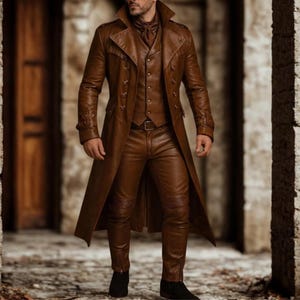 May include: A brown leather outfit consisting of a long coat, vest, and pants. The coat has a double-breasted design with multiple buttons and a wide collar. The pants have a quilted design on the knees. The outfit is worn with a brown scarf and black boots.