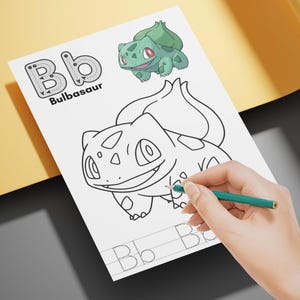May include: A white paper with a Bulbasaur coloring page and the letter "B" printed on it. A green and red Bulbasaur illustration is at the top. A hand is holding a green pencil, coloring the Bulbasaur.