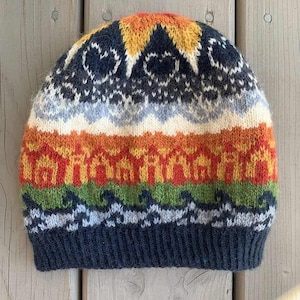 May include: A knitted beanie hat with a colorful geometric pattern. The hat features bands of orange, red, green, and blue, with white and navy blue accents. The top has a yellow and orange design.