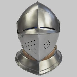 May include: A polished, silver-colored medieval helmet with a rounded top and a hinged visor. The visor features small ventilation holes and narrow eye slits. The helmet includes a neck guard and is designed for protection.
