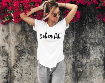 Pode incluir: Uma camiseta branca com o texto "sober AF" impresso em preto na frente.