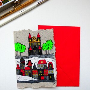 Cartão postal feito de papel reciclado e artesanal. Casas, contos de fadas, castelos.