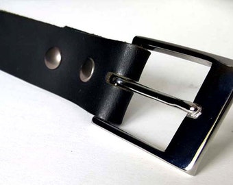 Könnte beinhalten: Ein schwarzer Ledergürtel mit einer silbernen Schnalle. Die Schnalle ist ein schlichtes, rechteckiges Design mit einer glatten Oberfläche.