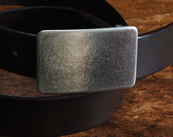 May include: A black leather belt with a silver buckle. The buckle has a textured surface.