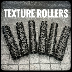 Puede incluir: Seis rodillos de textura negros con varios patrones, incluyendo ladrillos, escamas y diseños geométricos. El texto blanco "TEXTURE ROLLERS" se muestra arriba. Los rodillos son cilíndricos y parecen ser de plástico.