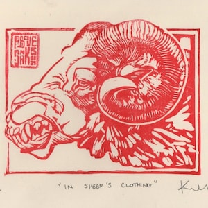 Peut inclure: Estampe linogravée rouge d'une tête de bélier avec de grandes cornes et une gueule ouverte, dans un cadre rectangulaire. L'estampe comprend le texte "IN SHEEP'S CLOTHING" et la signature de l'artiste. L'estampe est numérotée 1/12.