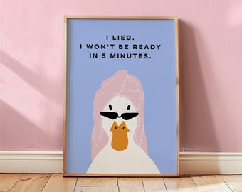May include: Framed art print featuring a cartoon duck wearing sunglasses and a pink towel on its head. The text on the print reads, "I LIED. I WON'T BE READY IN 5 MINUTES." The background is a light blue color.