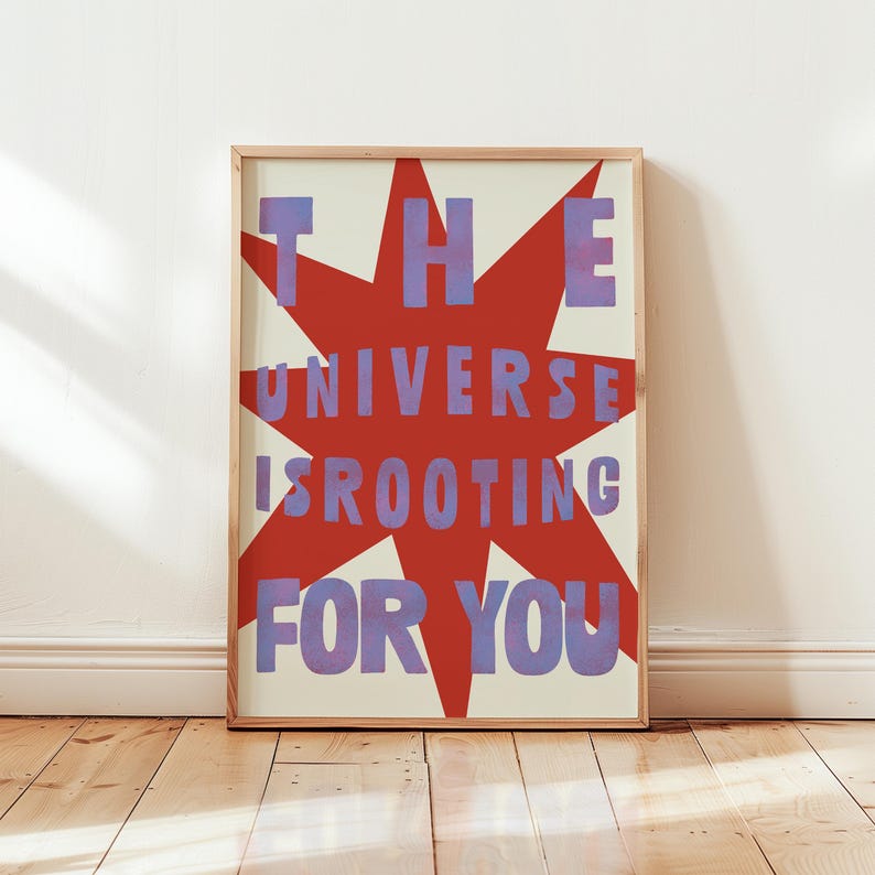 Pode incluir: Um cartaz motivacional com um design de estrela vermelha e o texto "THE UNIVERSE IS ROOTING FOR YOU" em letras roxas.