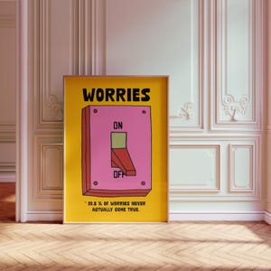 K&ouml;nnte beinhalten: Gerahmtes Poster mit gelbem Hintergrund und dem Wort "WORRIES" in Schwarz. Das Poster zeigt einen rosa Lichtschalter mit den Aufschriften "ON" und "OFF". Der Text "99,8 % DER SORGEN WERDEN NIE WAHR" steht unten.