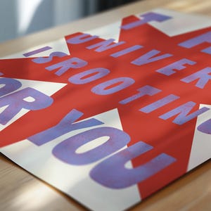 Pode incluir: Uma estrela vermelha sobre um fundo branco com o texto "O universo est&aacute; torcendo por voc&ecirc;" em roxo.