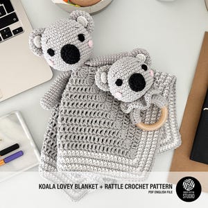 Puede incluir: Un juego de manta y sonajero de koala de ganchillo gris hecho a mano. La cara del koala presenta ojos negros, una nariz negra y mejillas rosas. La manta tiene un diseño texturizado. El sonajero tiene un anillo de madera. El texto "KOALA LOVEY BLANKET + RATTLE CROCHET PATTERN" es visible.
