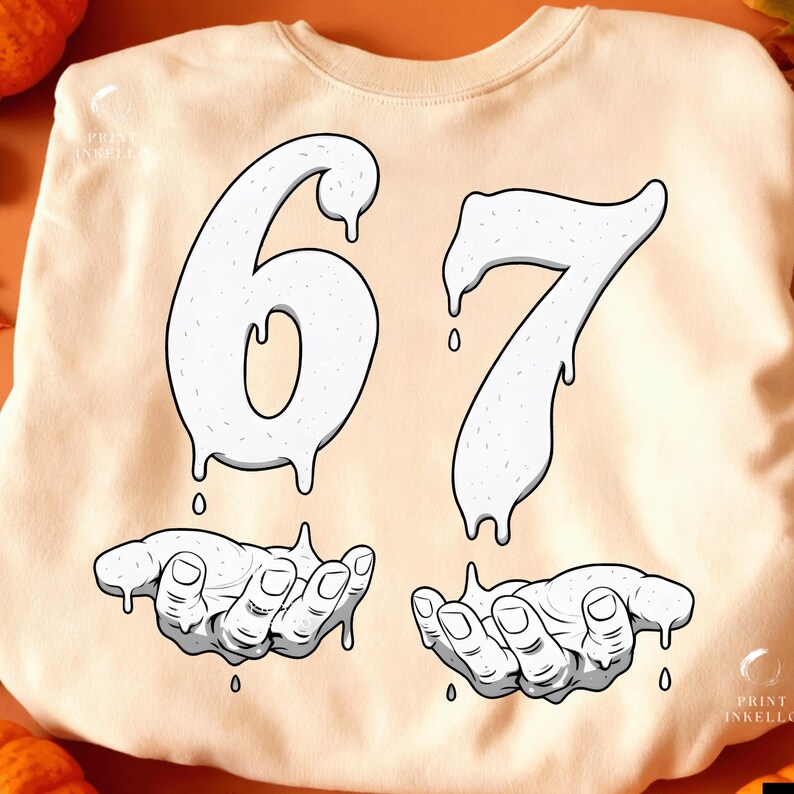 May include: Cream-colored sweatshirt with a graphic design featuring the numbers "67" in a dripping style, above two hands also in a dripping style. The design is in white with black outlines.