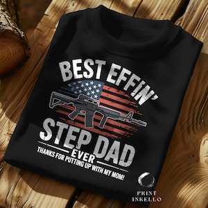 May include: Black crew neck sweatshirt with the text "BEST EFFIN' STEP DAD EVER" in white. The design includes an American flag and a rifle graphic. The text "THANKS FOR PUTTING UP WITH MY MOM!" is also included.