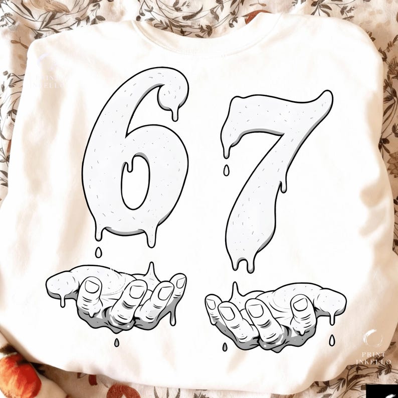 May include: White sweatshirt with a graphic design featuring the numbers "67" in a dripping style, above two hands also in a dripping style. The design is in black and white.