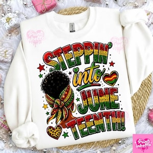 Op de afbeelding: Witte sweatshirt met de tekst "Steppin' into June Teenth!" in rood, groen en geel. Het ontwerp bevat een afbeelding van een vrouwenhoofd met een patroon hoofddoek, sterren en hartvormen. De sweatshirt is van het merk Gildan.