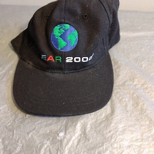 May include: Black baseball cap with a green, blue, and red embroidered globe and the text "EAR 2000".