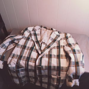 Può includere: Un blazer bianco con un motivo a quadri verde, arancione e bianco.