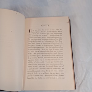 May include: An open book with text on aged paper. The title "GIFTS" is at the top of the page. The text is in black ink, with a large initial letter at the beginning of the first paragraph. The book's pages are yellowed.