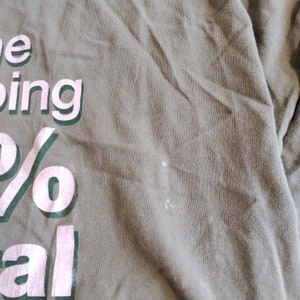 Puede incluir: Una camiseta verde con texto blanco que dice "The being 100% real"