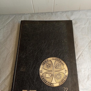 Puede incluir: Anuario de tapa dura negra con un emblema dorado que dice "Vinal Regional Technical School" y el año "'72". La portada también incluye el nombre "Dennis L. Kujawski".