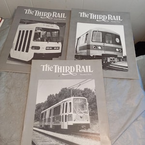 Puede incluir: Se muestran tres números antiguos de la revista "The Third Rail". Cada portada de revista presenta una imagen en blanco y negro de un tren. Los dos números superiores están numerados y el número inferior está etiquetado como "Número cinco".