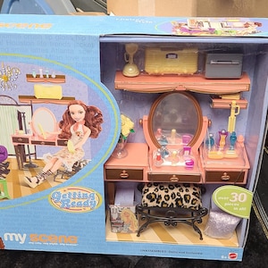 May include: A "My Scene Chelsea Style" doll playset in a blue box. The set includes a vanity with a mirror, a chair, and doll figures. The box features the text "Getting Ready" and illustrations of dolls.