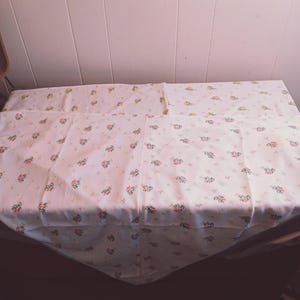 May include: A white tablecloth with a small floral pattern in shades of pink, yellow, and green.