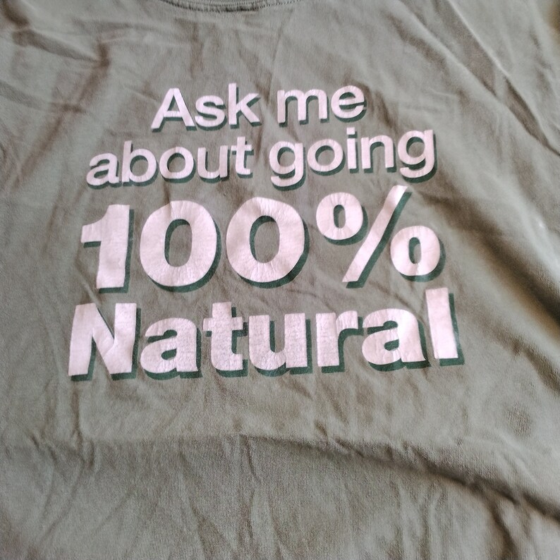 Puede incluir: Una camiseta verde con texto blanco que dice "Ask me about going 100% Natural".