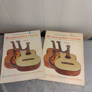 Może przedstawiać: Dwie stare książki z instrukcją gry na gitarze zatytułowane "The New Guitar Course" z obrazami gitar akustycznych na okładkach. Książki są ponumerowane 1 i 3 i kosztują 1,50 $ każda.