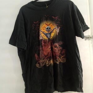 May include: Black t-shirt featuring a graphic from "The Nightmare Before Christmas." The design includes Jack Skellington in front of a full moon, bats, and the text "The Nightmare Before Christmas."