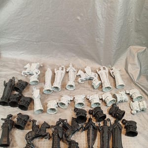 May include: A collection of black and white chess pieces featuring detailed sculpted figures including knights on horseback, rooks, bishops, and pawns. The set consists of various molded plastic pieces with hollow bases, displayed in a scattered arrangement.
