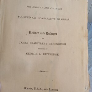May include: An antique book titled "Latin Grammar" with text in black font. The cover is aged with visible wear and tear. The book is "Revised and Enlarged" by James Bradstreet Greenough, assisted by George L. Kittredge. Published in Boston, U.S.A., and London in 1898.