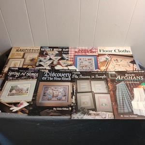 Pode incluir: Oito livros de padr&otilde;es de ponto cruz com capas coloridas. Os t&iacute;tulos incluem "Narcissus Old Print Collection", "Kathie's Bread Cloths", "Apple Bampler", "Floor Cloths", "Spring At Stoneg", "Discovery of the New World", "The Seasons in Sample" e "Strictly Afghans".