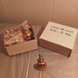 May include: A box of 10 gold-toned cabinet knobs with silver stems. The box is labeled "STOCK NO. H-97 Q'TY: 10 PCS."