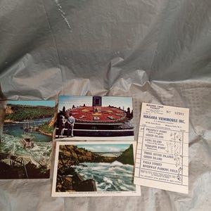 May include: A collection of vintage postcards and a round trip ticket from Niagara Viewmobile Inc. The postcards depict scenic views of Niagara Falls, including the rapids, a bridge, and a floral clock. The ticket lists various points of interest.