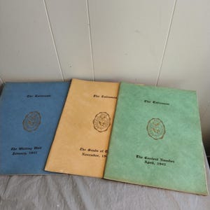 May include: Three vintage school yearbooks with blue, yellow, and green covers. Each cover features the school crest and the title "The Talisman". The titles of each yearbook are "The Wishing Well January, 1947", "The Sands of Time November, 1947", and "The Contest Number April, 1947".