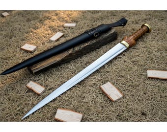 May include: A double-edged sword with a polished steel blade, a carved wooden handle, and a brass pommel. The sword is accompanied by a black leather scabbard featuring a metal belt loop attachment and decorative lacing details.