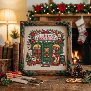 Könnte beinhalten: Eine quadratische Kreuzstichstickerei, die einen Weihnachtsbuchladen darstellt, gerahmt in einem dunklen Holzrahmen mit Tannenzapfen- und Tannengrün-Akzenten. Das Design zeigt eine grüne Ladenfront, festliche Dekorationen und verpackte Geschenke.