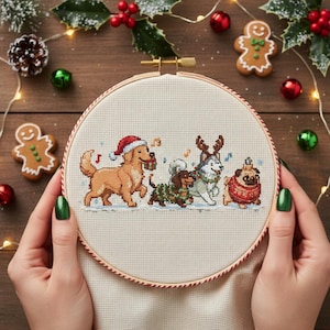 May include: Cross-stitch embroidery hoop with a Christmas-themed design of four dogs. A golden retriever in a Santa hat, a dachshund in a garland, a husky with antlers, and a pug in a sweater are depicted. The hoop is held by hands.