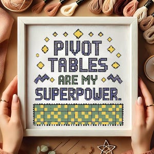 Könnte beinhalten: Ein weiß gerahmter Kreuzstich mit dem Text "Pivot Tables Are My Superpower." Der Kreuzstich zeigt ein violettes und gelbes Karomuster.