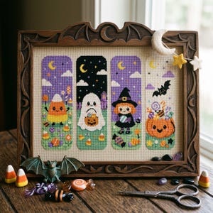 Peut inclure: Un cadre en bois sombre sculpté de motifs de chauves-souris contenant une broderie au point de croix représentant quatre panneaux verticaux sur le thème d'Halloween : un bonbon maïs, un fantôme, une sorcière et une citrouille remplie de friandises.