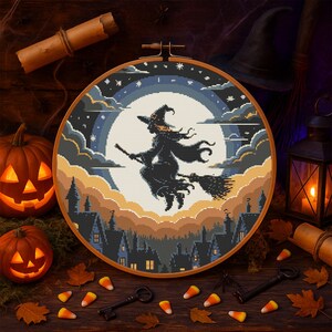 Flying Witch Halloween Cross-Stitch Pattern – Broomstick Witch Soaring Over Haunted Town with Full Moon
This atmospheric pattern features a bold silhouette of a witch flying on her broomstick across a glowing full moon, surrounded by layered twilight clouds and a starry sky. Below, dark rooftops and pointed turrets create a charmingly spooky village, perfect for Halloween decor and seasonal stitching.