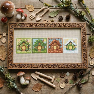 May include: A framed cross-stitch artwork featuring four miniature houses, each representing a different season. The houses are green, brown, and orange, with intricate details. The frame is made of carved wood, and the scene is decorated with wooden buttons and miniature garden tools.