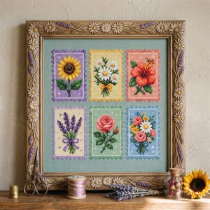 May include: A framed cross-stitch sampler featuring six floral designs resembling postage stamps. The designs include a sunflower, daisies, a hibiscus, lavender, a rose, and a mixed bouquet. The frame is wooden with daisy and lavender accents.