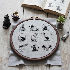 This fantasy cross-stitch pattern features a hobbit-style cottage illustrated across all four seasons, each framed within a decorative postage stamp border. Spring blooms with soft flowers and gentle sunlight, summer glows with lush greenery, autumn warms the scene with golden leaves, and winter settles into a peaceful snowfall beneath a glowing moon. The rounded door, grassy roof, and winding path tie each scene together, creating a cohesive yet varied seasonal collection.