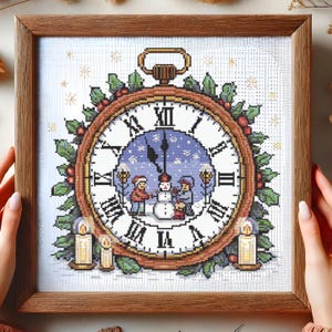 May include: A framed cross-stitch featuring a Christmas scene within a clock face. The clock has Roman numerals, a winter scene with a snowman and children, and is surrounded by holly and candles. The frame is made of wood.