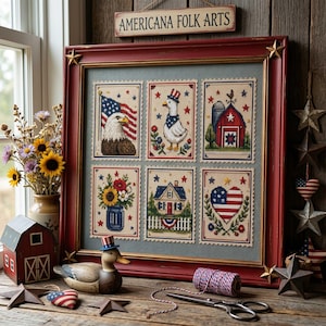May include: A framed Americana folk art piece with six cross-stitch designs featuring patriotic symbols like the American flag, an eagle, a goose, a barn, a house, and a heart. The frame is red with gold stars.