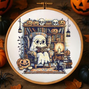Ghost Reading in Haunted Library Cross-Stitch Pattern – Cozy Ghost with Glasses in Armchair Surrounded by Books, Pumpkins, Skulls and Candles for Halloween Decor
This charming Halloween cross-stitch design features a sweet ghost nestled in an armchair reading Ghost Tales. The cozy haunted library setting is rich with spooky details – pumpkins grin from bookshelves, skulls rest on top of ancient tomes, and glowing candles light the room. A curious cat peers up from below
