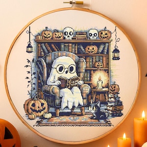 Ghost Reading in Haunted Library Cross-Stitch Pattern – Cozy Ghost with Glasses in Armchair Surrounded by Books, Pumpkins, Skulls and Candles for Halloween Decor
This charming Halloween cross-stitch design features a sweet ghost nestled in an armchair reading Ghost Tales. The cozy haunted library setting is rich with spooky details – pumpkins grin from bookshelves, skulls rest on top of ancient tomes, and glowing candles light the room. A curious cat peers up from below