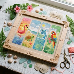 Könnte beinhalten: Ein gerahmtes Kreuzstich-Kunstwerk mit vier vertikalen Tafeln, die tropische Szenen zeigen: einen Flamingo, eine Meeresschildkröte, einen Delfin und einen Papagei. Der helle Holzrahmen hat Wellen- und Palmenblatt-Schnitzereien. Muscheln und Meeresglas umgeben den Rahmen.